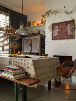 Jude’s artwork can be seen on the chimney breast, garlands of ivy are strung above, old books and vases of dried flowers and branches decorate.