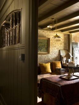An old prison cell door, is used to partition the corridor from the snug in Elle Kemp and Martin Gane's home, converted from an Victorian pig pen